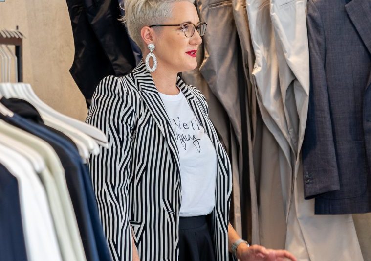 Adele Leahy, personal stylist, standing in front of a rack of clothes looking like she is passing on some pearls of wisdom to someone outside of the shot.